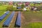 Blue solar photo voltaic panels mounted on metal frame standing on ground with green grass in field