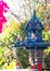 Blue spirit house in thailand with flower vases