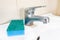 Blue sponge for washing dirty faucet with limescale, calcified water tap with lime scale on washbowl in bathroom, house cleaning