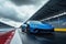 A blue sports car accelerates down the race track with great speed, A blue Lamborghini on a racing track, AI Generated