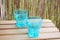 Blue stacked empty glass cups on a wooden surface with a blurred background