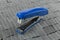 Blue stapler on heap of staples