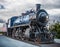 Blue steam locomotive on a cloudy morning
