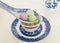 A blue-striped white porcelain spoon scoops three glutinous rice balls of different flavors,with a cup of tea aside.