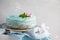Blue stylish cake with flowers and mint on wooden box. Copy space