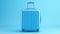 Blue suitcase on pastel blue background. minimal travel concept