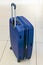 Blue suitcase on wheels. Baggage of a tourist. Waiting for travel by train, plane, ship