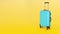 Blue suitcase on a yellow background. Copy space for text. 3d render