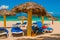 Blue sun loungers with umbrellas on the beach. On the background of the turquoise waters of the Caribbean. Playa Esmeralda, Holgui