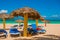 Blue sun loungers with umbrellas on the beach. On the background of the turquoise waters of the Caribbean. Playa Esmeralda, Holgui