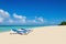 Blue sunbeds on sandy Caribbean beach
