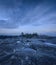 Blue sunset on a rocky forested island. Scenic view with dramatic sky