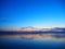 Blue sunset sky over the lake with light smoky clouds over the horizon