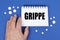 On the blue surface of the tablet, a hand and a notepad with the inscription - GRIPPE