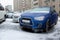 The blue SUV and other cars stand in the city frozen and icy from the rain in winter. Blocked by ice.