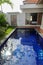 blue swimming pool with exotic wooden terrace in teak natural flooring and blue water