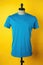 A blue t-shirt on a mannequin on a yellow background