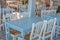 Blue table and white chairs in a typical tavern in Greece