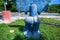 Blue Taino idol on grass back view