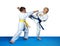 On the blue tatami small athletes are training paired exercises karate