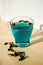 Blue tea in a transparent cup on a light background and a wooden table.