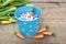 Blue tiin bucket filled with candy eggs and mini carrots on rust