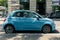 A blue tiny Fiat 500 parked by street