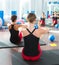 Blue toning ball in women pilates class rear view