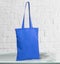 Blue tote bag canvas. on glass table and white wall