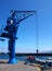 Blue tower crane in a harbor dockyard with sea and boat