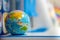 A blue toy globe rests on a student`s desk