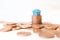 Blue toy house money coins stack on white background. Mini house model on stack coins pile money home loan concept for