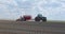 Blue tractor cultivator or seeder plows the land, prepares for crops. dust little planet inside green grass round frame background