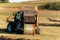 Blue tractor packs straw. Autumn work on the farm. Tractor on the field. Ecological agriculture