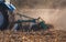 Blue tractor plows the field and removes the remains of previously mown corn.