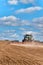 A blue tractor sows grain. Farm work on a farm in the Czech Republic. Tractor on a wheat field. Agricultural machinery