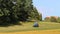 Blue tractor turn dry grass, hay near forest, Rural scene, Czech landscape