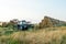 The blue tractor uses a hydraulic manipulator to stack round bales of hay in pyramids for storage and drying. Machinery works in