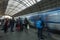 A blue train from Ceske Drahy arriving to the Prague main train station, with many passangers waiting to board the train