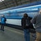 A blue train from Ceske Drahy arriving to the Prague main train station, with many passangers waiting to board the train