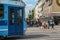 Blue tram and people waiting to cross the lively street in Oslo on a summer day