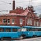 Blue trams on the background of an old red tram depot.