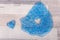 Blue transparent glitter slime with heart shape on a wooden surface