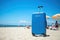 Blue travel luggage on the beach. Summer vacation. Generative AI