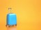 Blue travel suitcase on orange background