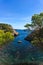 Blue turquoise clear water in Calo d& x27;en Monjo bay at Mallorca surrounded by plants and trees