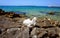 Blue and turquoise color tone sea surface and skyline with a rocky coast and heart shaped stone in the center