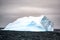 Blue and turquoise iceberg in dark Southern Ocean with dark and cloudy evening  sky in Antarctica