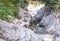 Blue turquoise river with narrow in the canal of a gray smooth canyon covered with greenery