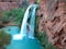 Blue turquoise waterfall on red travertine